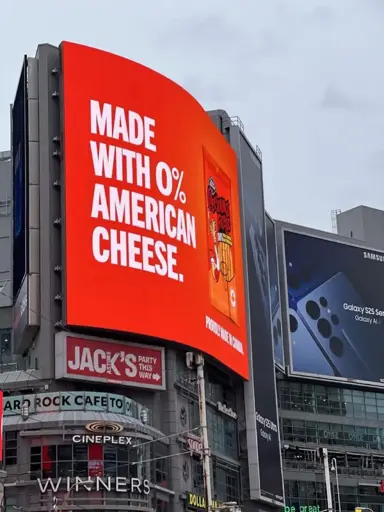 BOICOTE: Um outdoor em Toronto mostra a resposta dos canadenses às provocações dos Estados Unidos: "Feito com 0% de queijo estadunidense".