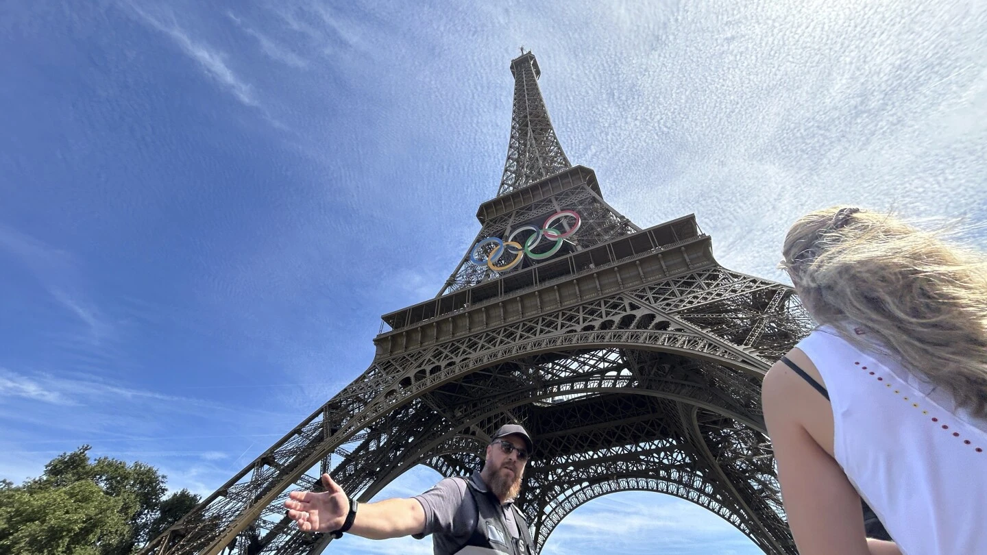 A man is seen climbing the Eiffel Tower, prompting an evacuation hours before closing ceremony