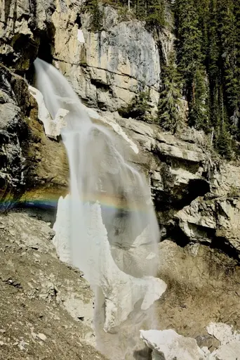 Panther Falls with the remaining snow chunks scartered about the landscape, with a nice rainbow being formed in the mist from the falls.