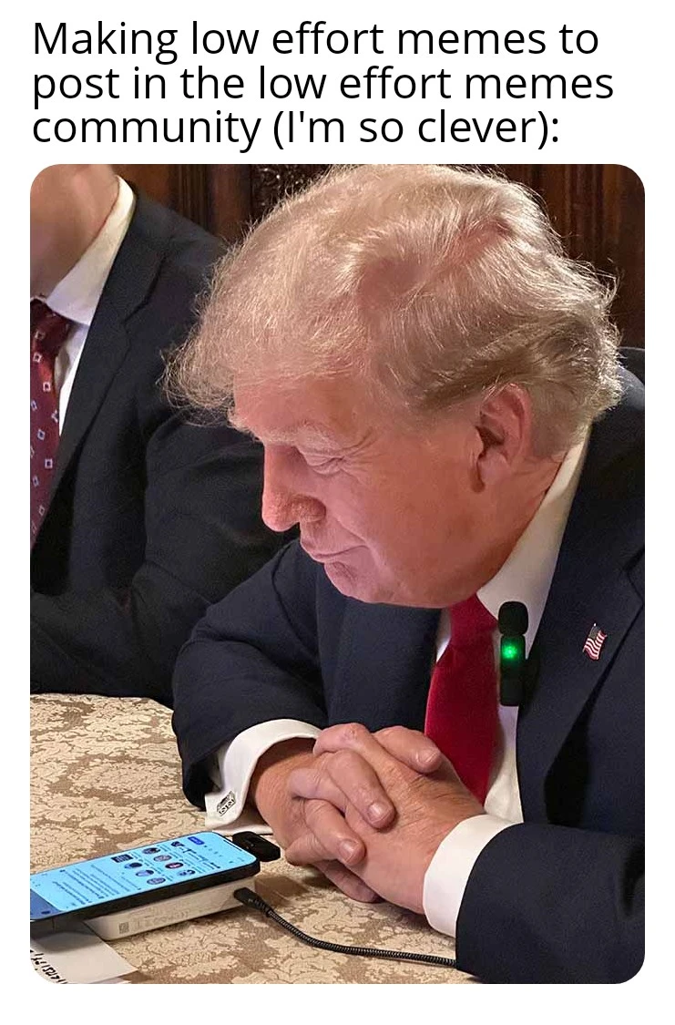 image of Donald Trump looking at his phone, smiling, with the caption "making low effort memes to post on the low effort memes community (I'm so clever)"